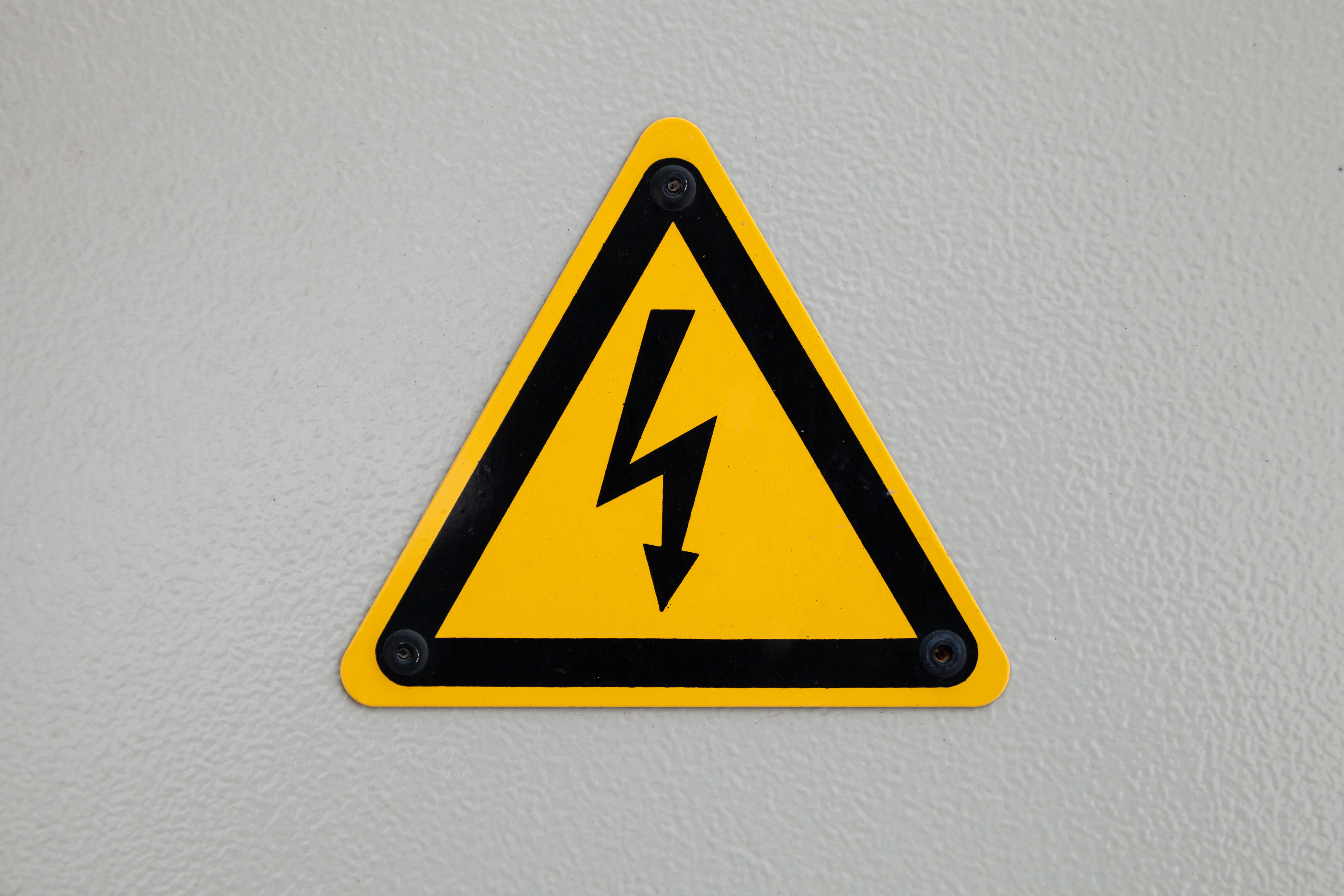 high-voltage-triangle-warning-sign-mounted-on-gray-future-tech